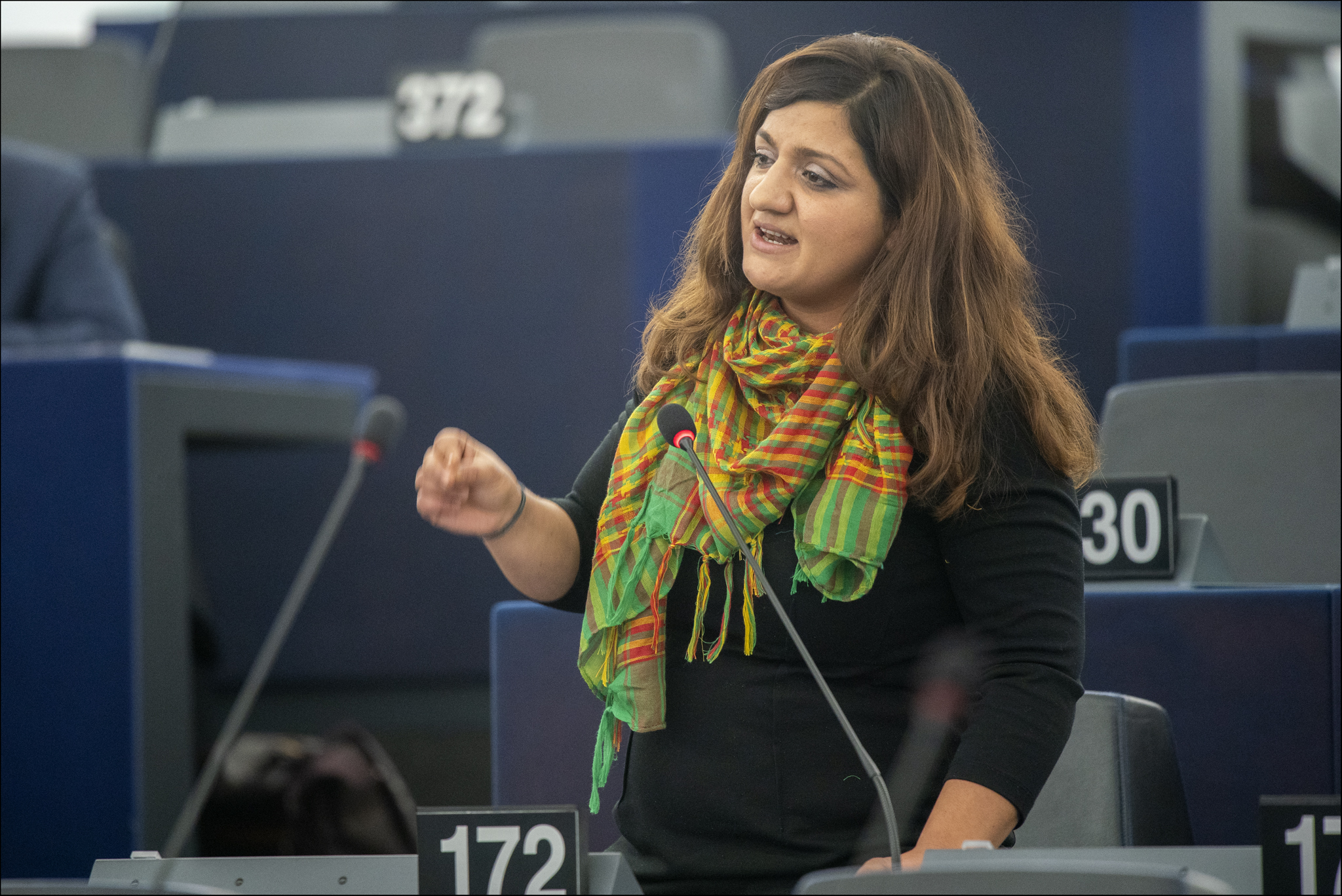 Özlem Demirel mit einem kurdischen Tuch im Plenum, eine Zwischenfrage stellend